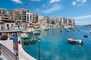 斯利马Seafront Traditional Maltese Townhouse Balluta Bay的城市中一条有船的河流