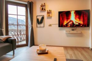 NeefJacuzzi, Sauna, Garten, Terrasse, Grill, 6 Personen, Moselstaustufe, Netflix, Sky, Smart TV的客厅墙上有火