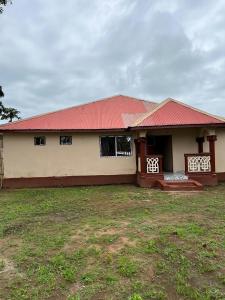 弗里敦Yogi Home Stay Near Freetown Airport的一座红色屋顶的房子和一个院子