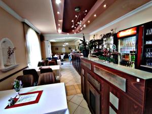 哈卡尼Átrium Hotel Harkány的餐厅设有酒吧,配有桌椅