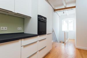 汉堡Hanseat Apartments的厨房配有白色橱柜和黑色用具