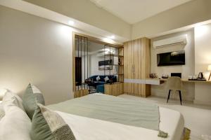 古尔冈Saltstayz Premier Executive Serviced Apartment - Golf Course Extension Road的一间卧室配有一张床和一张书桌