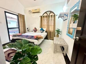 阿伯来GR Stays - Duplex 3bhk Villa With Pool Arpora I Baga Beach 5 mins的植物间内一间卧室,配有两张床