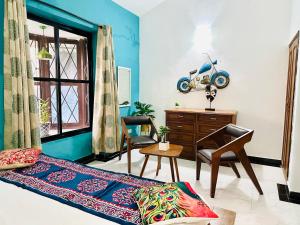 阿伯来GR Stays - Duplex 3bhk Villa With Pool Arpora I Baga Beach 5 mins的一间卧室配有一张床、一张桌子和一把椅子
