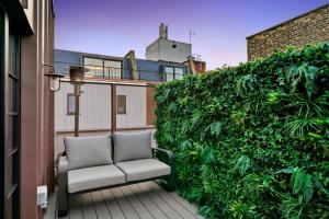 伦敦2 Bed Lux Apartments near Central London FREE WIFI by City Stay Aparts London的阳台的沙发,带绿色的树 ⁇ 