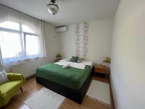 杰尔凯斯库特利基特旅馆的一间卧室设有一张绿色的床和一个窗户。