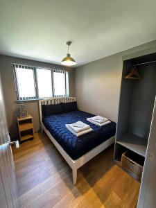 格拉斯哥Countryside Chalet near Glasgow的一间卧室配有一张带蓝色棉被的床
