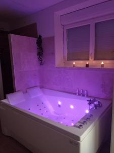 SacyBulles de Lune的紫色浴室设有浴缸,内配灯