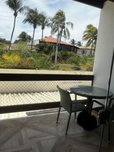 萨尔瓦多Samba Villa da Praia的阳台配有桌椅和棕榈树。