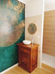 SacyBulles de Lune的一间带水槽的浴室和墙上的一幅大画