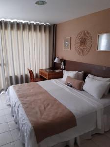 萨尔瓦多Samba Villa da Praia的一间卧室配有一张大床和一张书桌