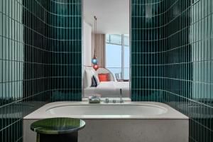 迪拜W Dubai - Mina Seyahi, Adults Only的一间带浴缸的浴室和一张沙发