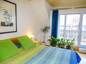 美因茨City-Dachapartment Mainz的一间卧室配有带绿色枕头和植物的床