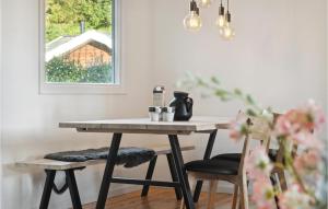 霍尔拜克Beautiful Home In Holbk With Kitchen的窗户间里的一张桌子和两把椅子