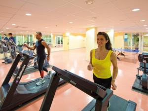 奥斯赛拜-屈隆斯博恩库隆斯博恩莫拉达度假酒店的男人和女人在健身房跑步机上行走