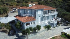 毕达哥利翁Villa Karras的一座大型蓝色房屋,设有红色屋顶