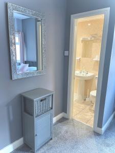 斯凯格内斯The Cresswell Inn的浴室设有镜子、盥洗盆和卫生间