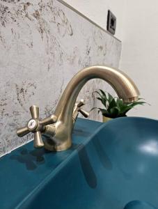 库尼奥Good Times Accomodation Cuneo的浴室水槽和蓝色柜台上的金色水龙头