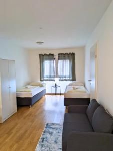 维也纳Vienna´s Danube Apartments的一间带两张床和一张沙发的客厅