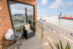 浦耳Harbours Edge的阳台配有桌椅,享有水景。