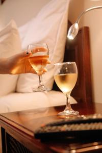 利马Hotel Carrera的两杯酒,放在床边的桌子上