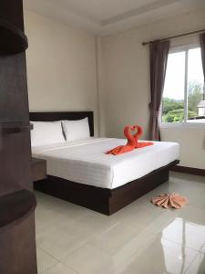 甲米镇Hassana Apartment的一间卧室配有一张带橙色毛巾的床