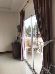 甲米镇Hassana Apartment的一间设有滑动玻璃门并通向阳台的客房