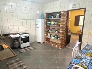 瓜拉派瑞Casa do SOL的厨房配有白色冰箱和炉灶。