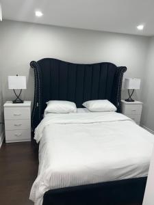 布兰普顿Tosam Luxury Lodge Two Bedroom Suite的一间卧室配有一张带白色床单和两盏灯的大床