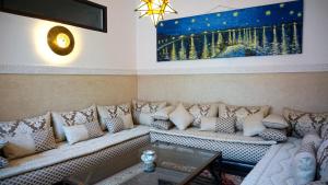 马拉喀什RIAD KALE POLIS的客厅配有沙发和墙上的绘画