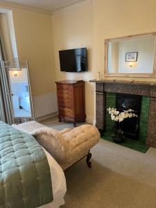 阿尼克Oronsay Guest House的客厅设有壁炉和电视。