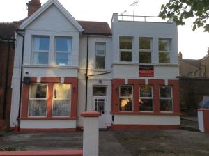 滨海绍森德Malvern Lodge Guest House- Close to Beach, Train Station & Southend Airport的白色和红色的房子,设有窗户