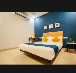 勒克瑙Nilansh homes and hotels的一间卧室设有一张蓝色墙壁的大床