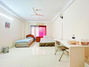 达卡Maya Eco Apartment Service的客房设有两张床和一张书桌