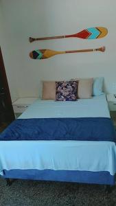 瓜拉派瑞Segunda Casa- Seu cantinho na Praia do Morro em Guarapari - Quartos suítes 2 até 4 pessoas的一张带蓝色床单和枕头的床
