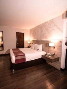 利马阿酷酒店的酒店客房配有一张床铺和一张桌子。