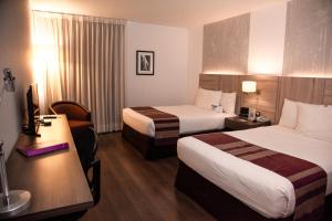 利马阿酷酒店的酒店客房配有两张床和一张书桌