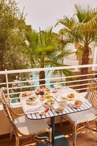 圣安东尼奥TRS Ibiza Hotel -All Inclusive Adults Only的阳台上摆放着食物盘的桌子