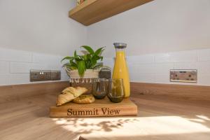 海伍德A spacious home from home with spectacular views的面包和一瓶水的切板和植物