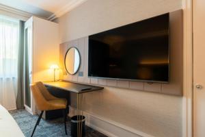 霍尔假日皇冠曼切斯特机场酒店的酒店客房的墙上配有电视