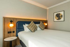 霍尔假日皇冠曼切斯特机场酒店的一间卧室配有一张大床和一张桌子