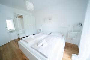 赖弗尼茨Apartment Seekind by Cosy Homes的白色卧室配有白色床和2条白色毛巾