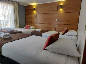 蒙特港Hotel Angelmontt的一间酒店客房,房间内设有三张床
