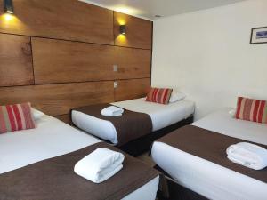 蒙特港Hotel Angelmontt的酒店客房,配有两张带毛巾的床