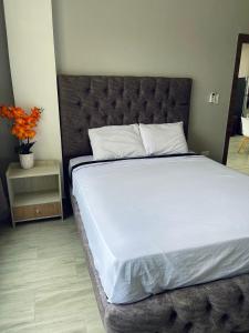 萨利纳斯Departamento exclusivo en salinas的一间卧室配有一张大床和大床头板