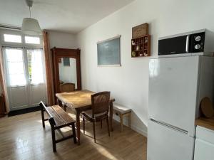 吉维尼Cosy Giverny的厨房以及带桌子和冰箱的用餐室