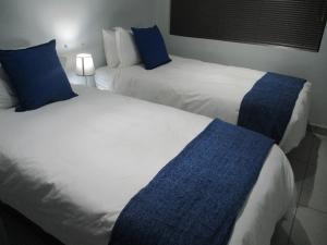布隆方丹LEKKER RUS的两张位于酒店客房的床,配有蓝色枕头