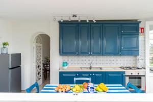 皮雅诺迪索伦托Villa Fanella, between Sorrento & Amalfi的厨房配有蓝色橱柜和水果桌