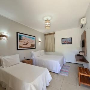 路易斯科雷亚Pousada Coqueiro Beach的一间酒店客房,设有两张床和电视