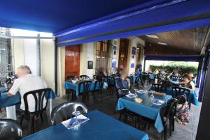 滨海比拉萨尔Hotel Tres Leones的一群坐在餐厅桌子上的人